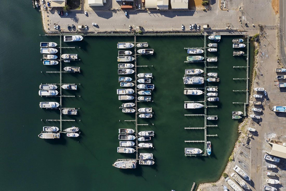 Overhead view of Fishing Boat Harbour with 3 fingers of pens mostly full of boats.