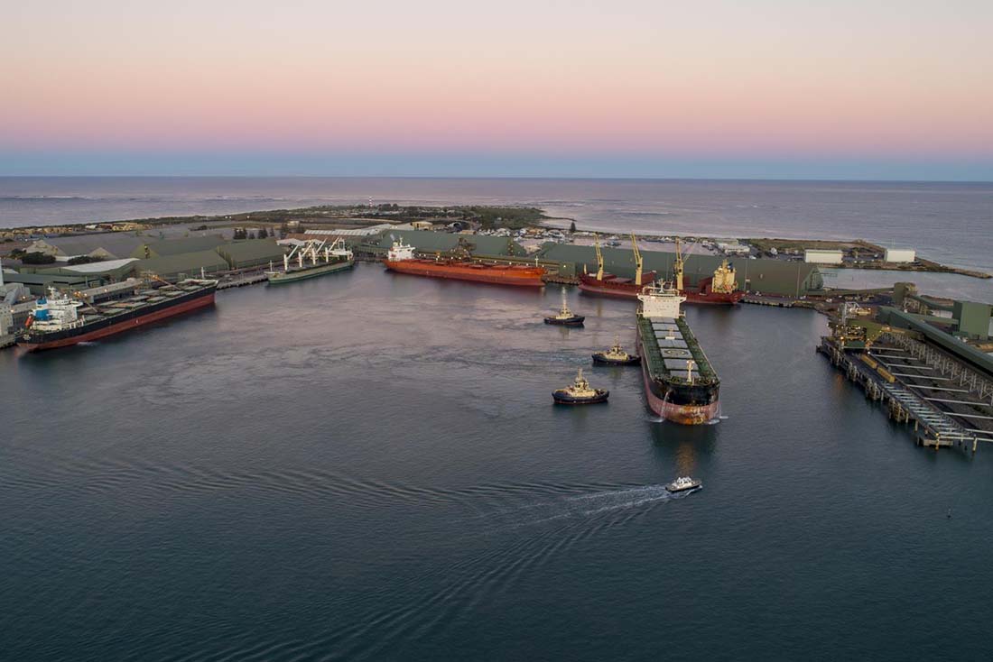 South-western view of Geraldton Port with 5 ships and 3 tugboats in view.
